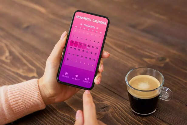 Woman using menstrual calendar app on mobile phone