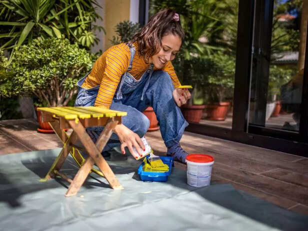 WOMAN PAINTING A CHAIR