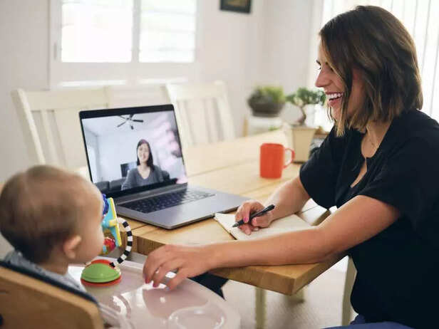 A young mom attending web conference with her her baby.