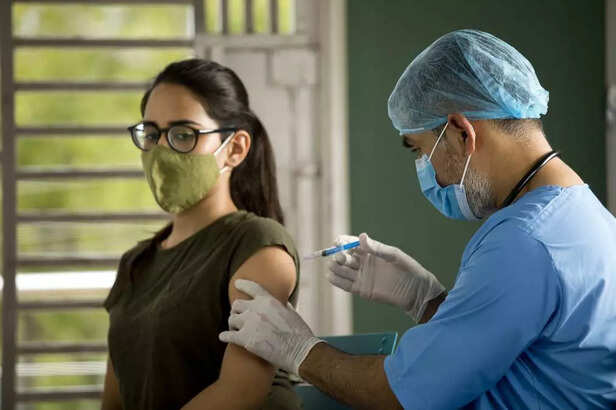 Doctor injecting vaccine to female patient