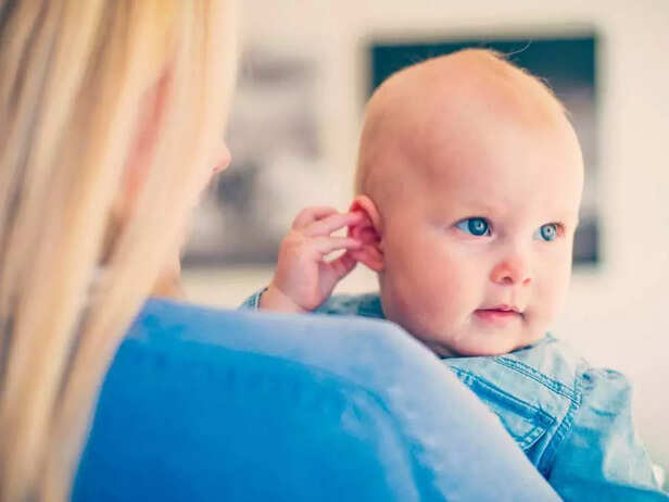 baby holding his ear