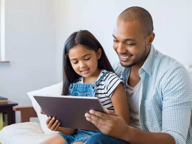 father and daughter looking at tablet