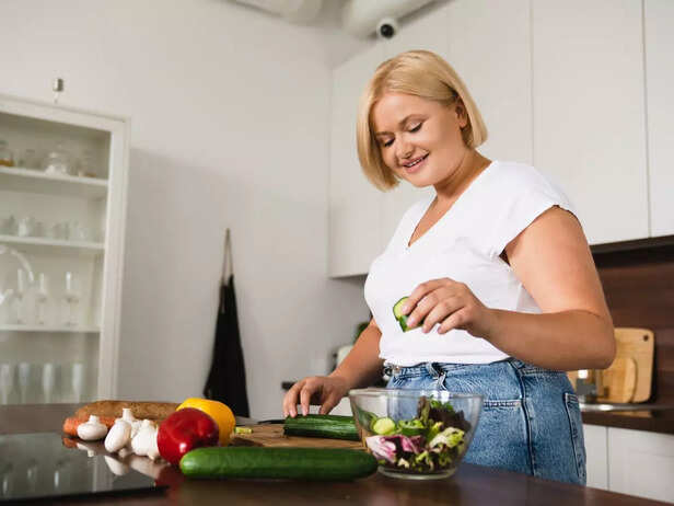 overweight woman cooking healthy meal