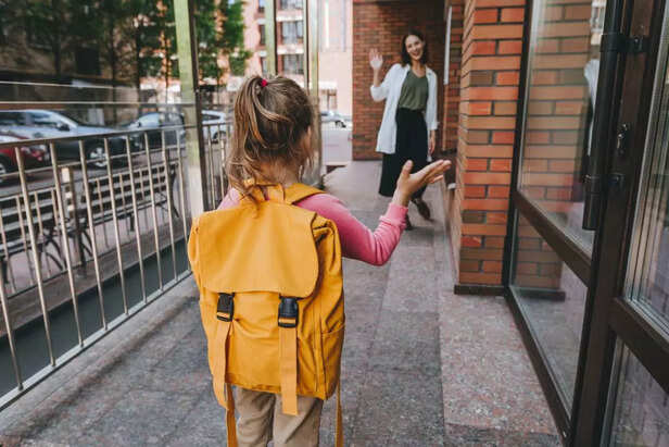 little girl saying bye to parent