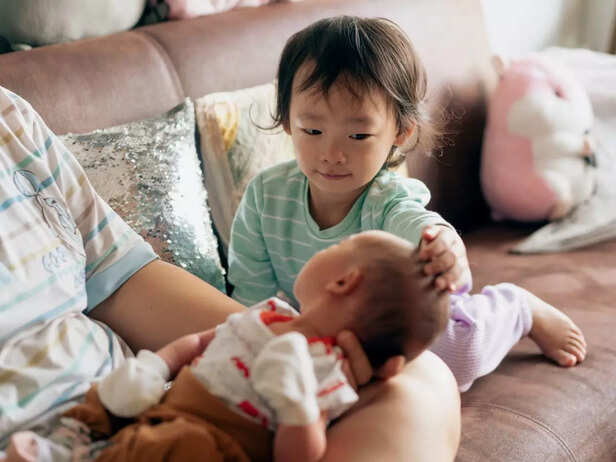 Toddler playing with the new baby