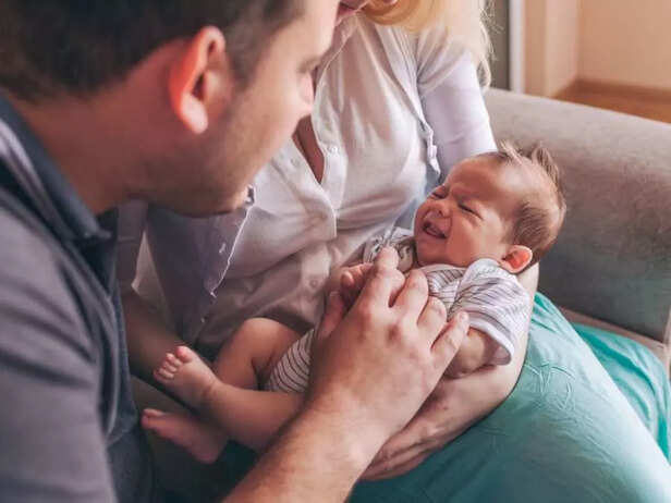 parents taking care of a crying baby