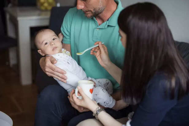baby being fed by parents