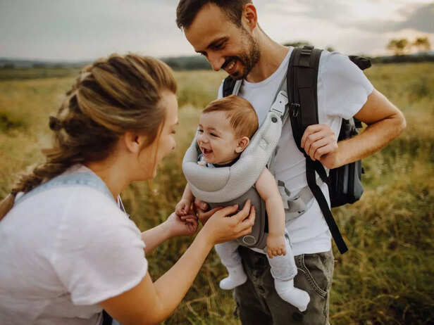 parents with baby talking in the field