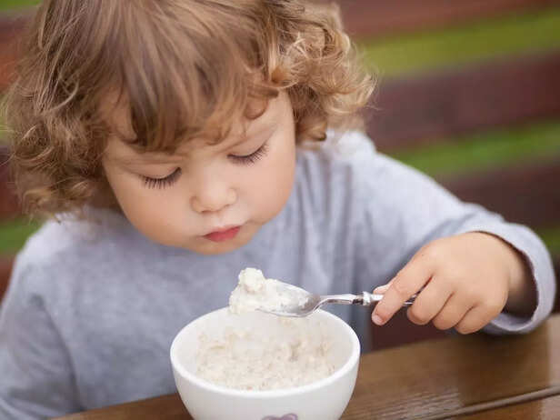 Cute toddler girl having breakfast. stock photo