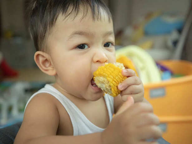 child biting into corn