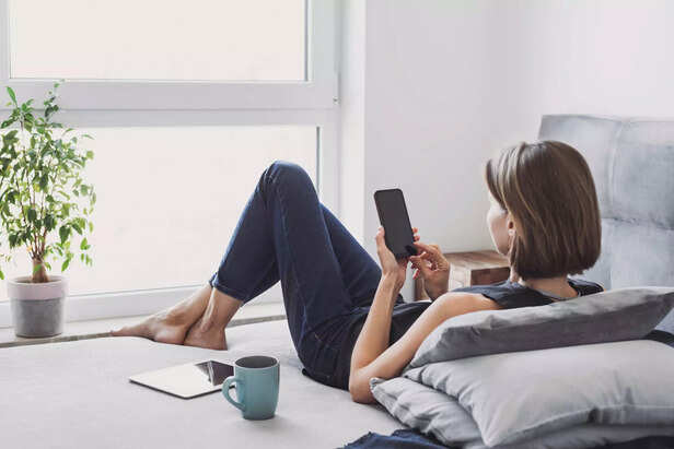 Woman resting at home and using smartphone