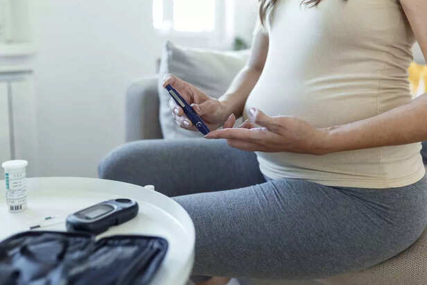 Blood sugar testing at home. Pregnant Woman Checking Blood Sugar Level At Home. Diabetic Checking Blood Sugar Levels. Pregnant Woman checking blood sugar level by glucometer and test stripe at home
