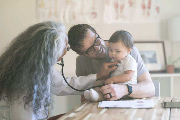 Female pediatrician examines baby during medical appointment