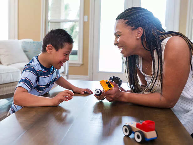 Mid adult therapist uses play therapy with young boy