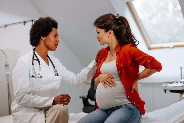 pregnant woman talking to doctor