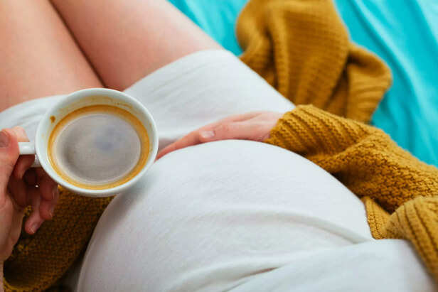 Pregnant woman drinking coffee.