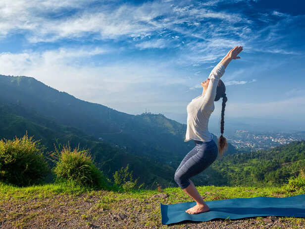 Woman doing yoga asana Utkatasana outdoors