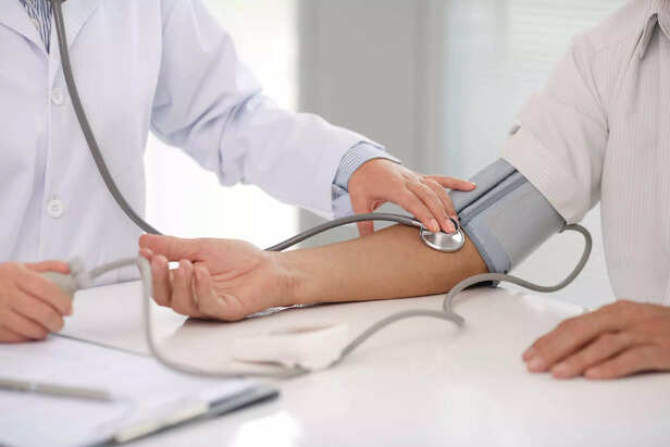 Doctor checking patients blood pressure