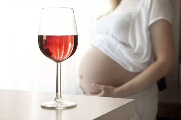Pregnant woman and a glass of wine - drinking mother, social problems