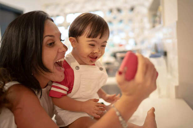 Mother and Down Syndrome son taking a selfie after eating chocolate