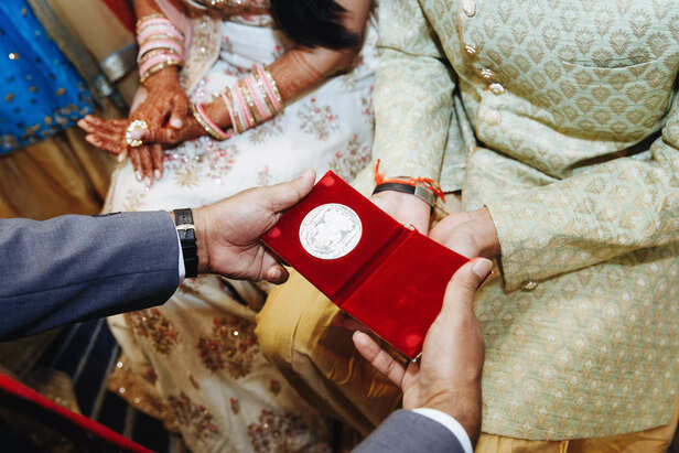 Man Giving Gift to Newly Wedded Couple