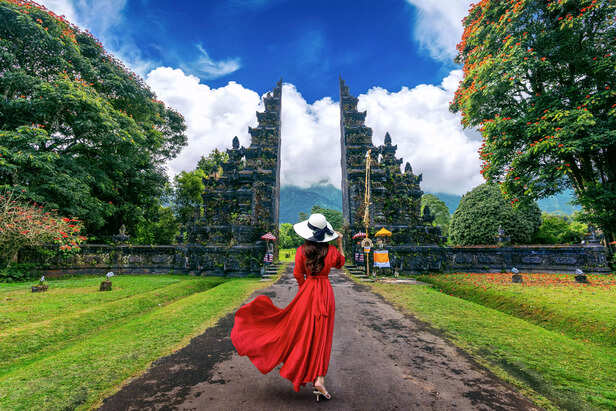woman-walking-big-entrance-gate-bali-indonesia