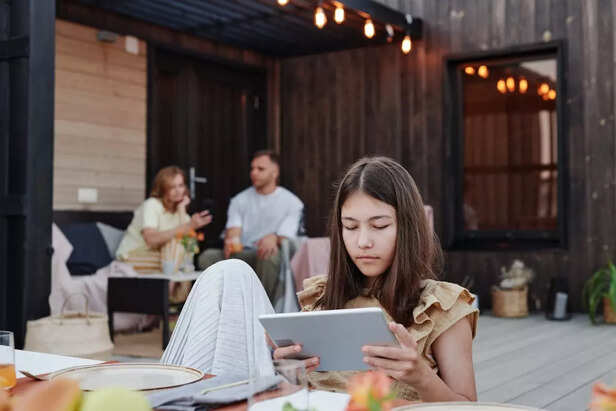 A Girl Sitting Alone with Parents Sitting Behind