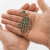 front-view-hands-holding-hamsa-pendant