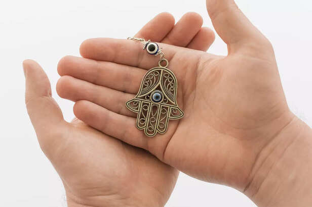 front-view-hands-holding-hamsa-pendant