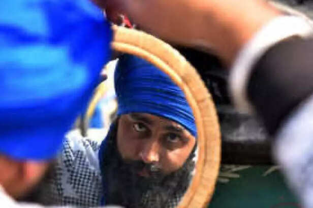 A Sikh man tying his turban.
