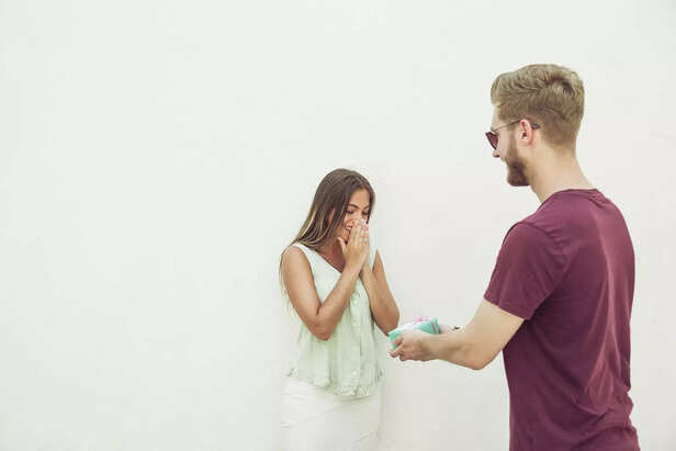 man-giving-gift-his-surprised-girlfriend-min