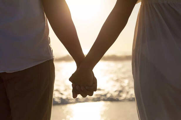 couple-standing-together-hand-hand-beach