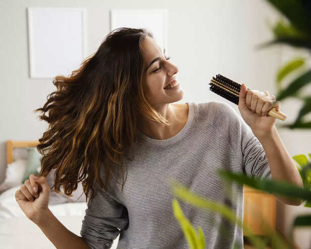 happy-woman-singing-into-hairbrush-home