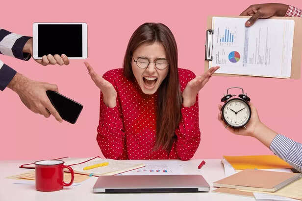 brunette-woman-sitting-desk-surrounded-with-gadgets-papers