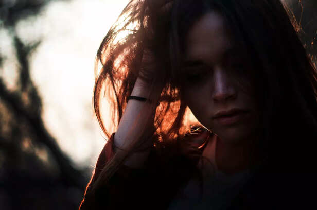 "Woman in Deep Thought or Emotional Distress in Natural Backlight"