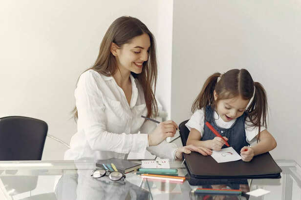 A child proudly showing a drawing to a smiling parent