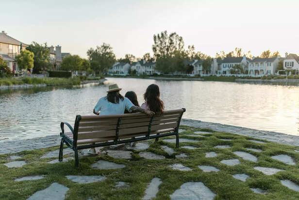 A parent and child sitting together quietly at sunset