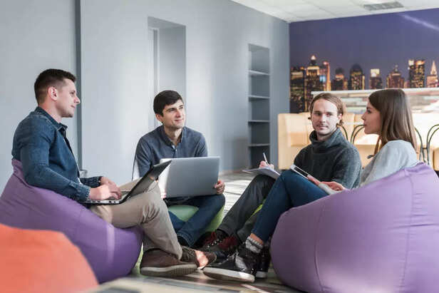 A group of diverse students sitting with laptops