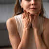 A person gently touching their dark neck. Image Credit: Freepik