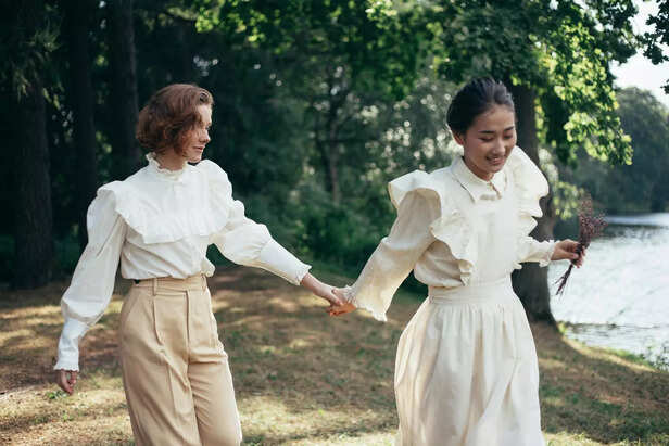 Women in Old-Fashioned Clothing Holding Hands