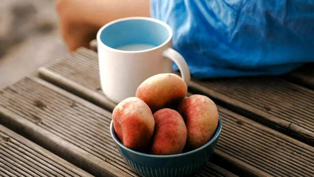 A girl sitting with a bowl of peach