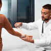 Doctor Bandaging Child's Arm in Clinic
