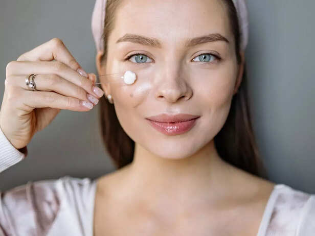 Girl applying cream on her face