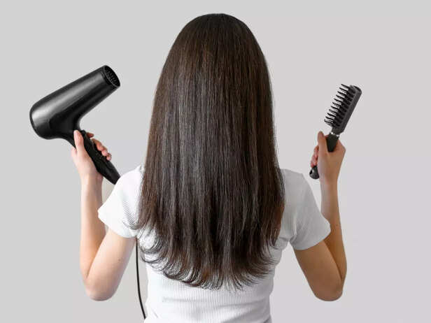 Women with hair dryer and hair brush