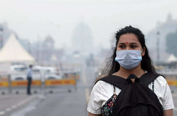 New Delhi, Oct 29 (ANI): A woman wears mask amid pollution at Kartavya Path, in ...