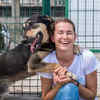 Happy Shelter Dog Hugging Volunteer During Adoption Day
