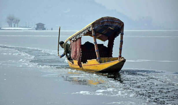 A-Shikara-owners-breaks-frozen-water-to-row-his-boat-on-Dal-Lake-1-scaled