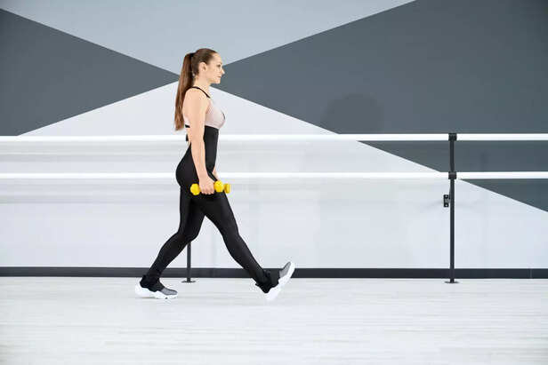 A Woman Walking With Dumbbells