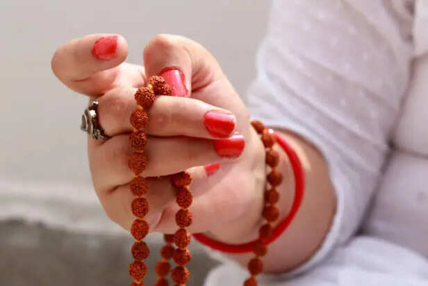 Devotee meditating while holding Rudraksha mala