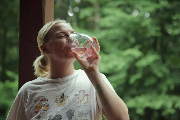 Person drinking water outdoors in summer